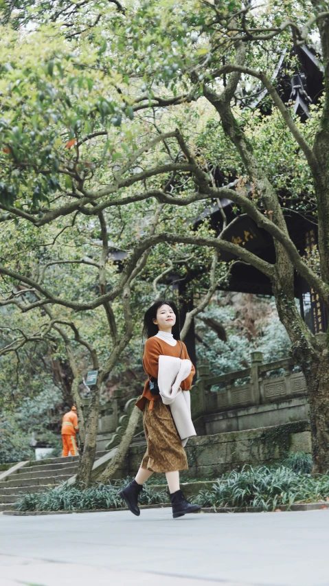 a woman walks down the street carrying a bag