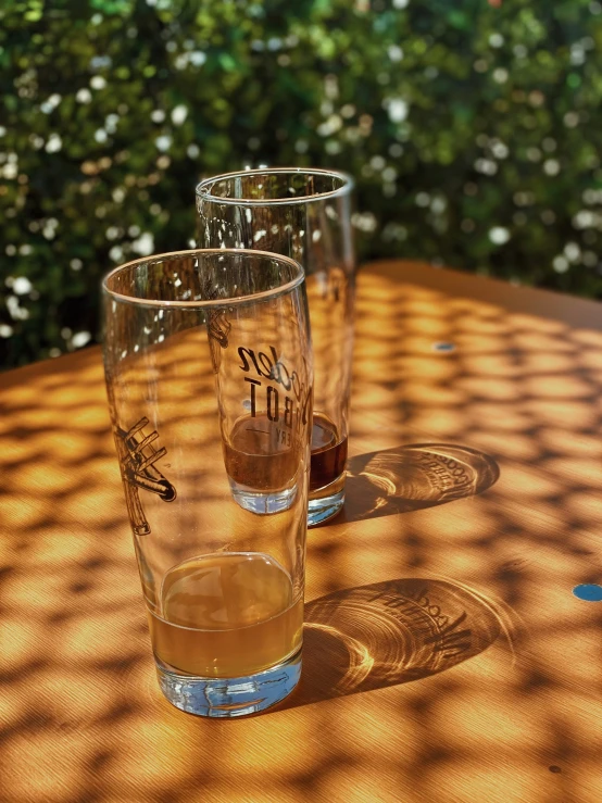a couple of glasses sitting on top of a wooden table