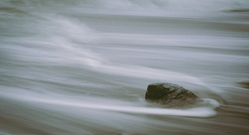 rocks are seen in the water on a gloomy day