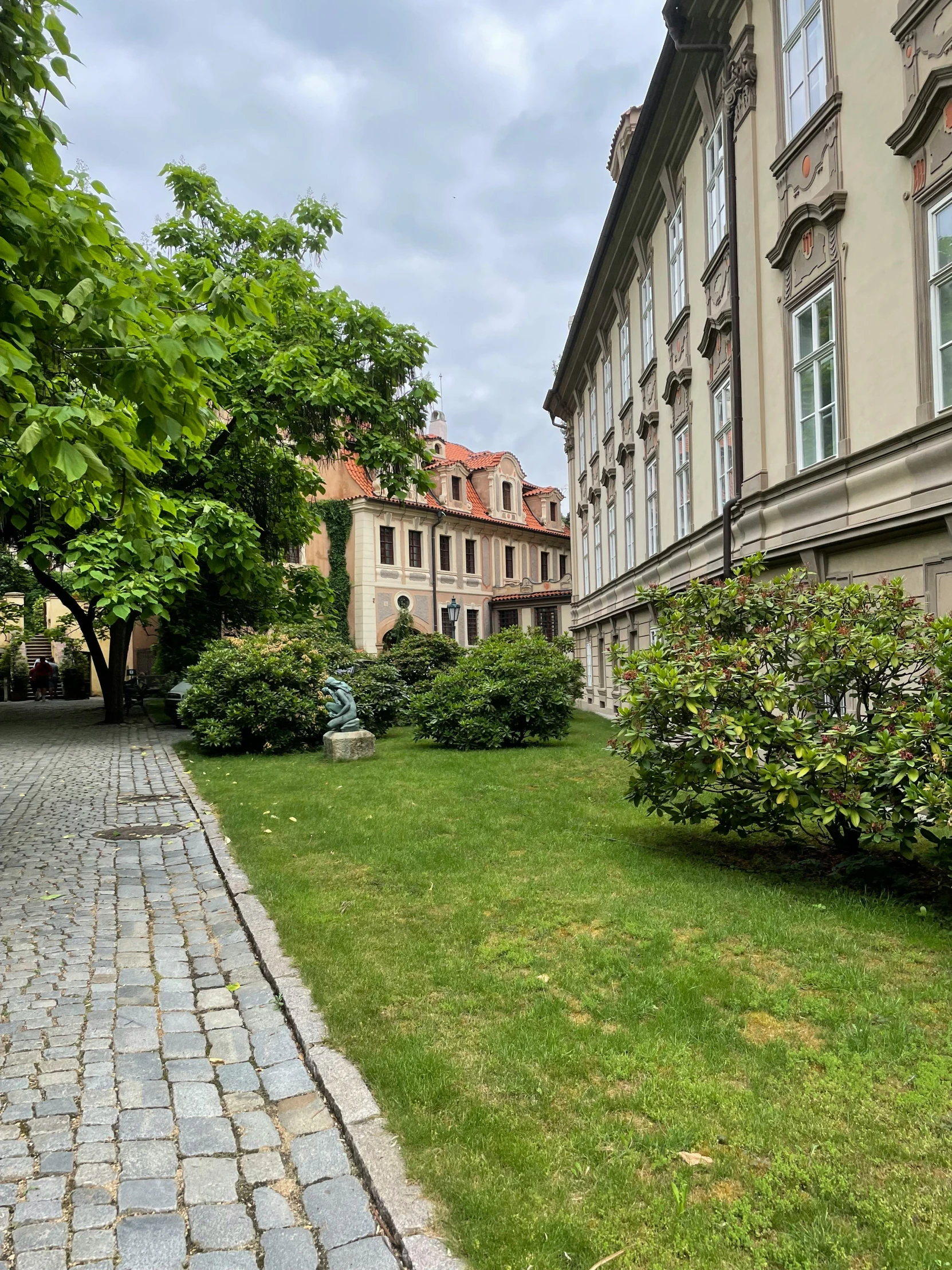 several buildings and trees line a sidewalk on a cloudy day