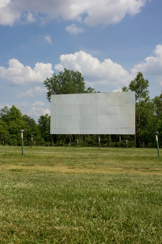 people are playing with kites near a large screen