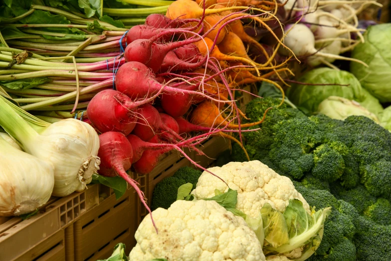 vegetables are shown sitting in bins with red onions