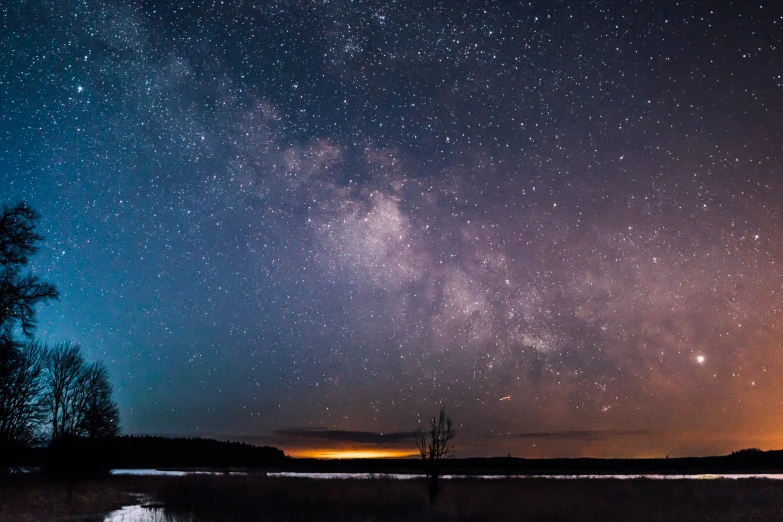 night time view of clouds, water and stars