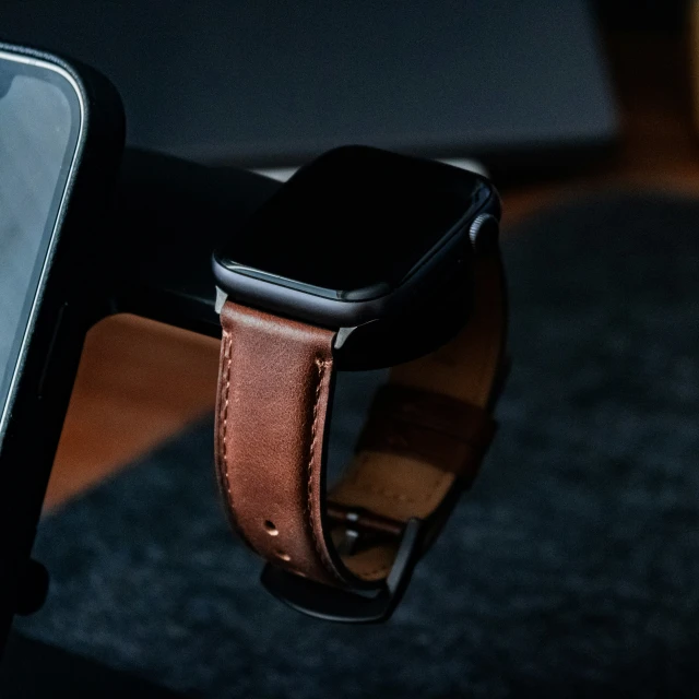 a close up of an apple watch with a brown leather band
