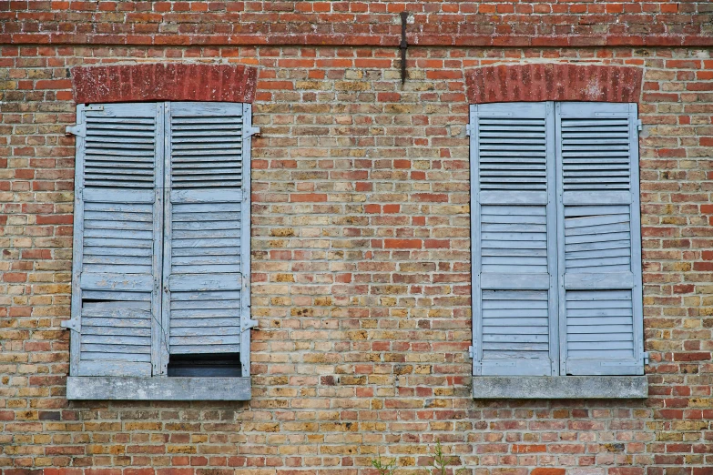 two shutters on the side of a brick wall
