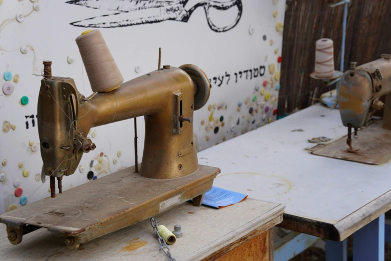 the two old sewing machines are sitting next to each other