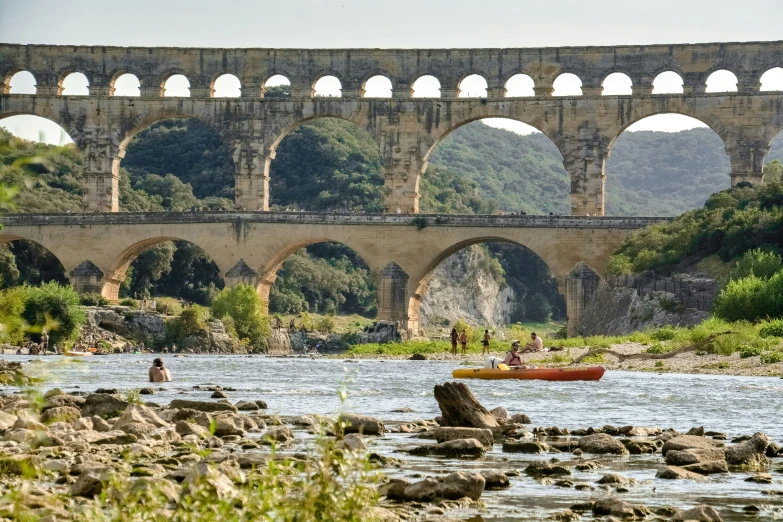 an old bridge sits next to a river and a kayak