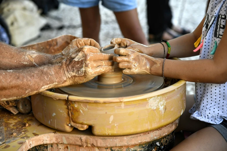 people are using clay on the wheel in the shape of a boat