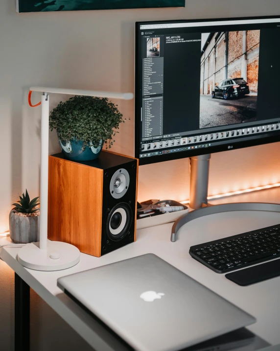 a home computer and laptop sit on a desk in front of a window