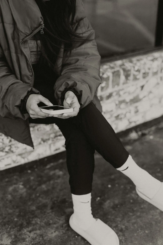 woman texting on her cellphone while wearing a fur hat and knee socks