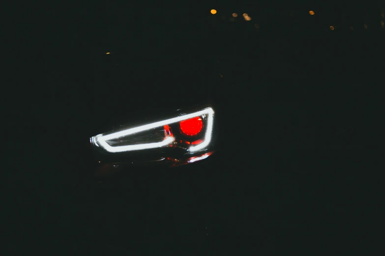 a car's taillight is shown in the dark