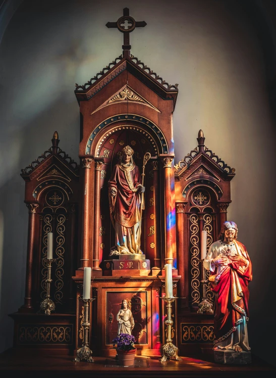 a wooden alter with three people and a large statue