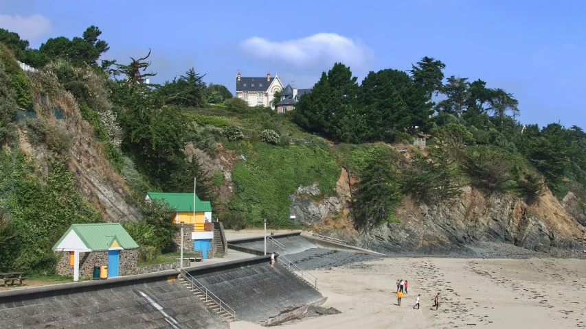 two people standing on the beach looking over the sand