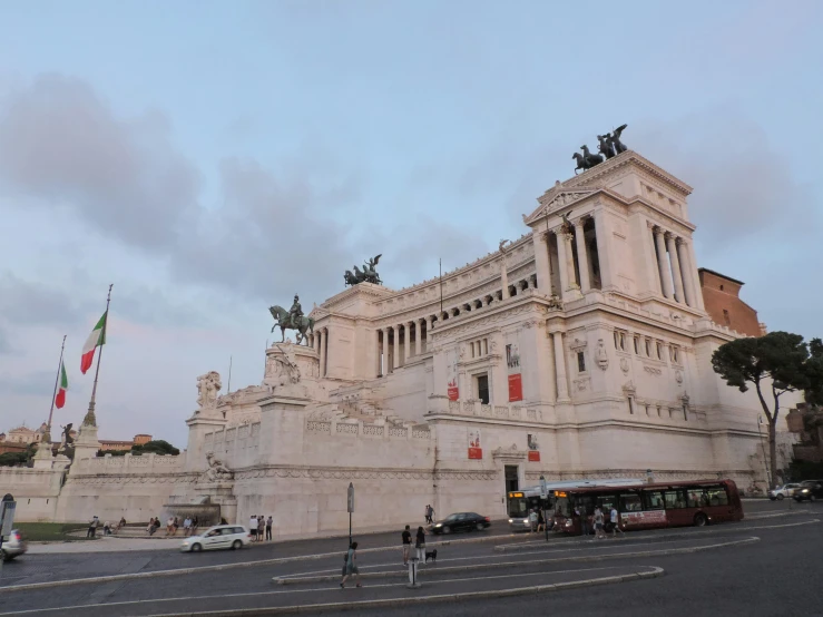 a large white building has flags on top