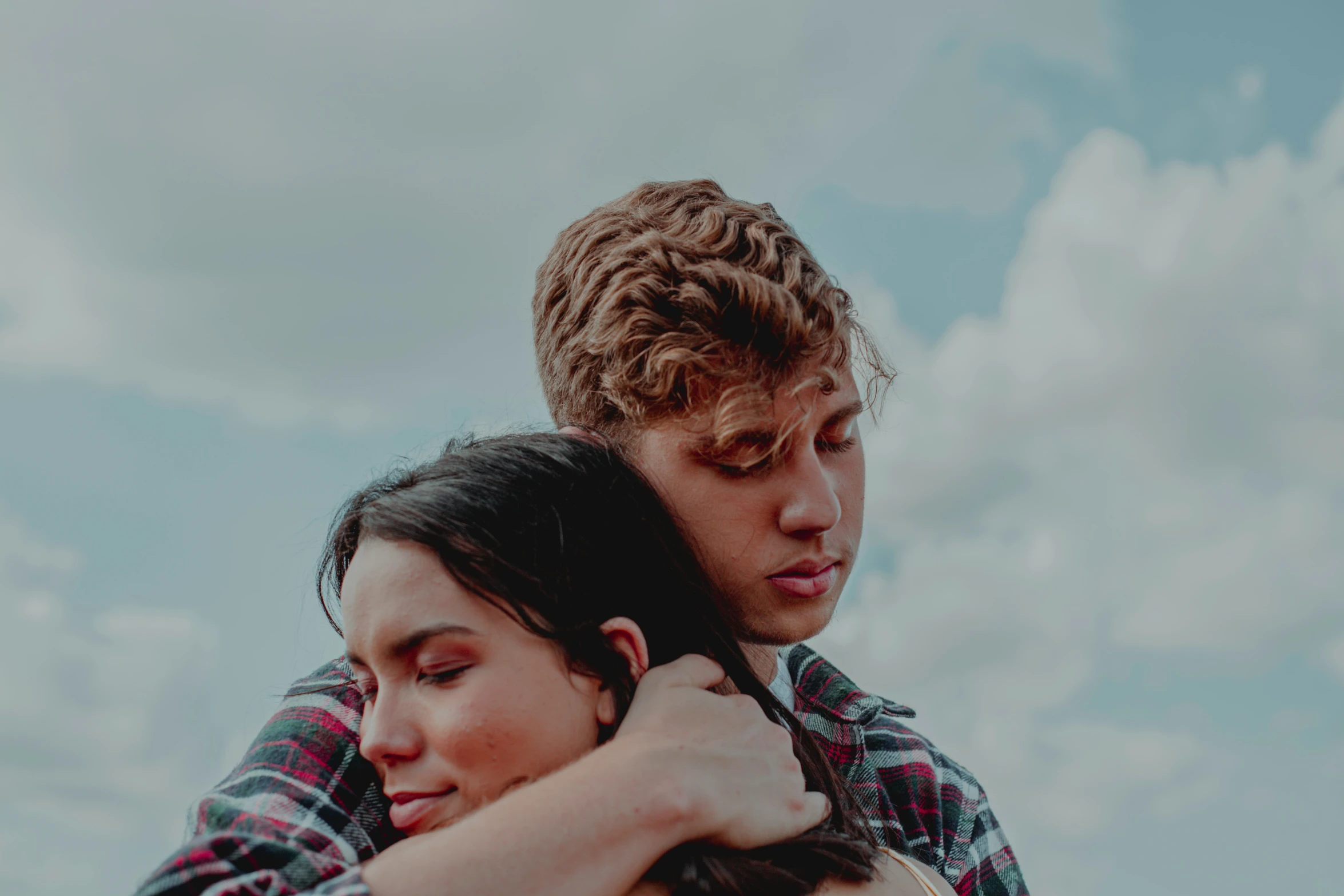 a man in a shirt is hugging a woman