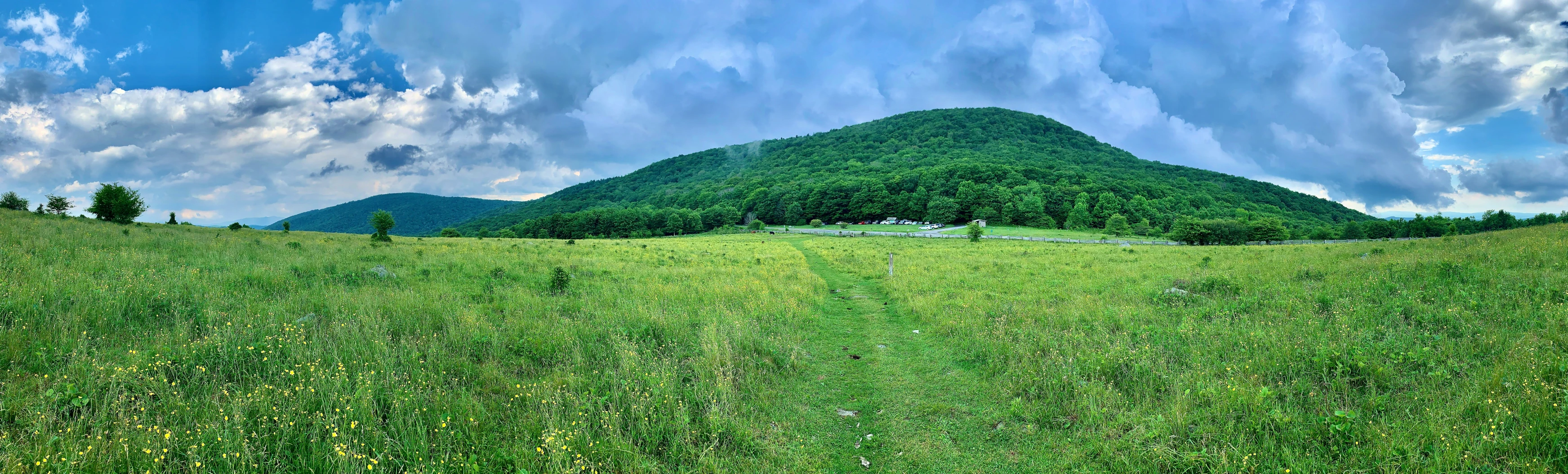 a view of some mountains and grass and sky