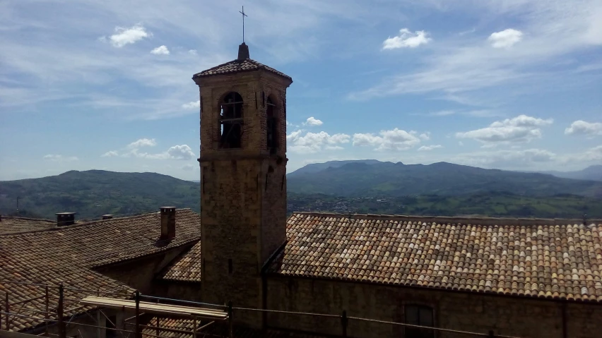 the clock is in front of the building with the mountains behind it