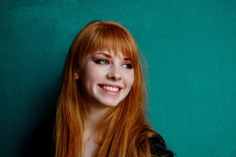 a young woman with red hair posing for a portrait