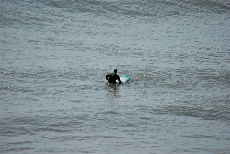a man on a surfboard paddling in the ocean