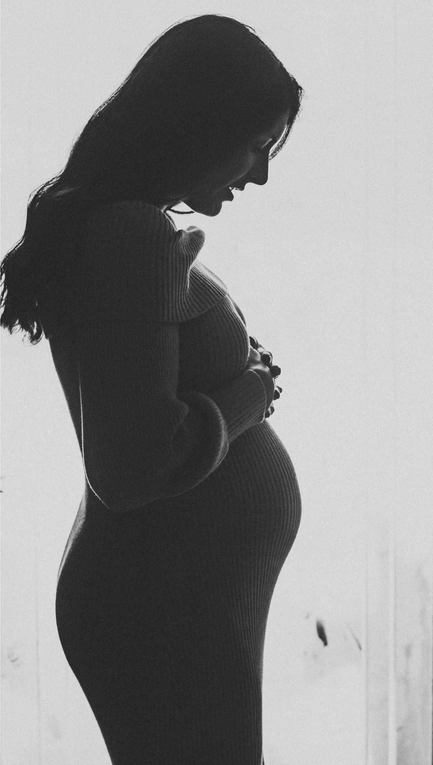 a pregnant woman in front of a window