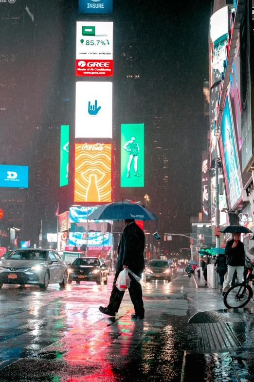 pedestrians with umbrellas crossing on busy city street in the rain