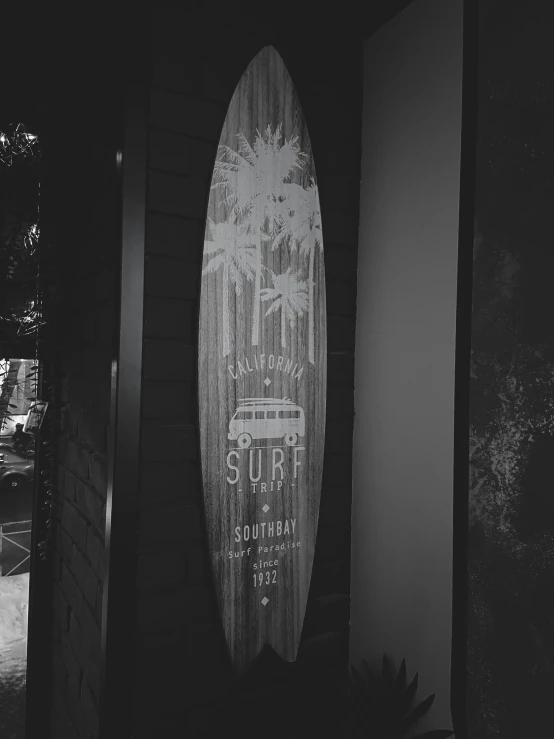 a wooden surfboard is sitting outside of a building