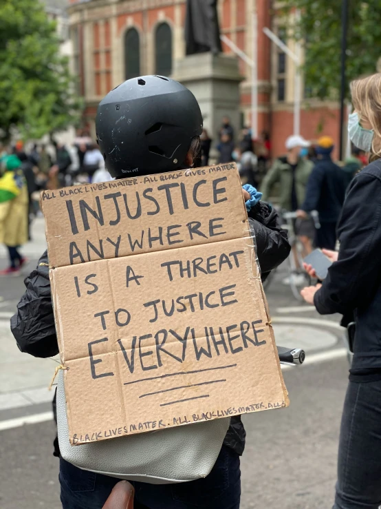 a person holding a sign on the side of the road