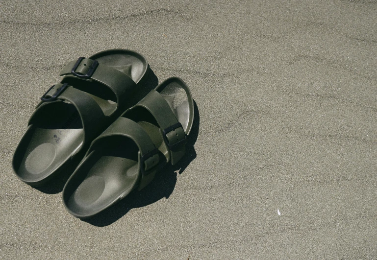 a pair of black shoes sitting on top of cement