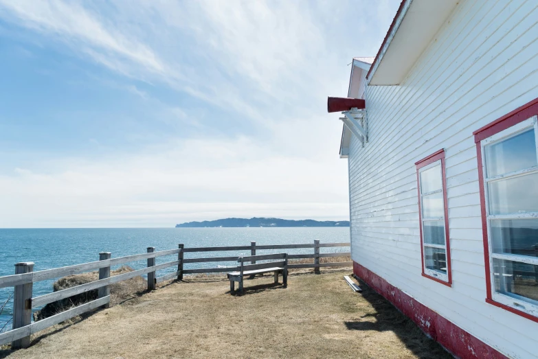 a small house on the beach with a lake in the background