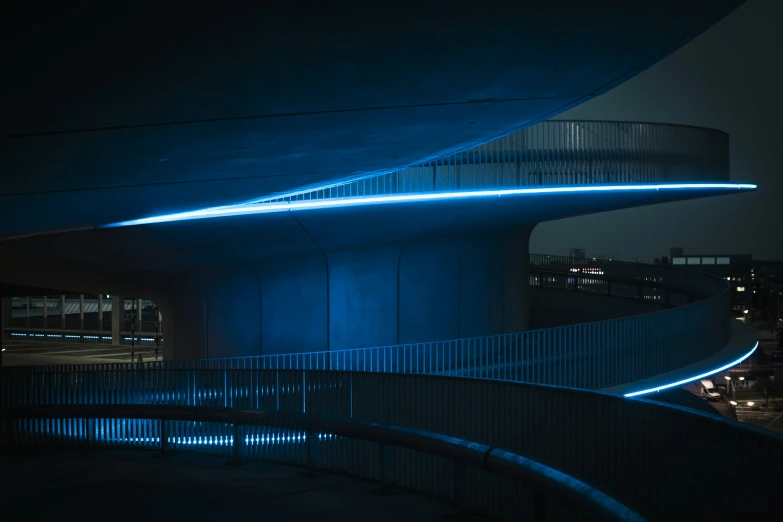 light lines shine along the side of an elevated walkway