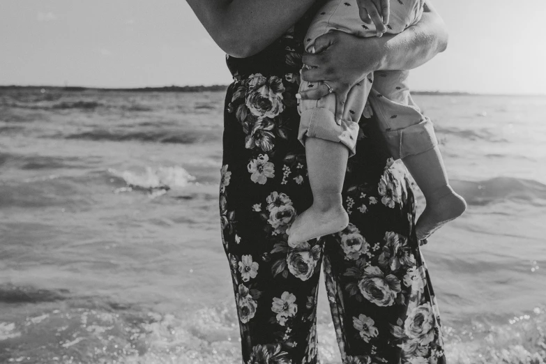 a mother holding her child on the beach