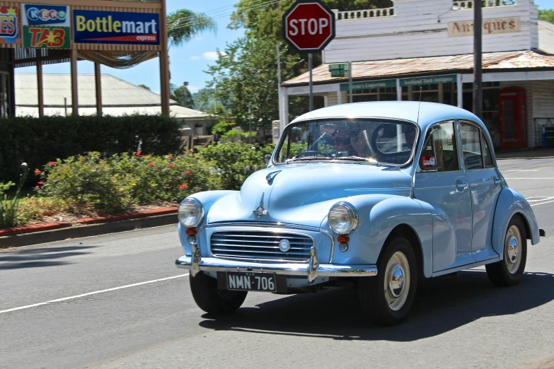 a blue car is driving down the road