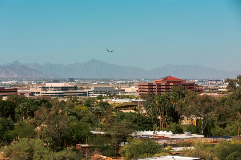 an airplane is flying through the air over several buildings