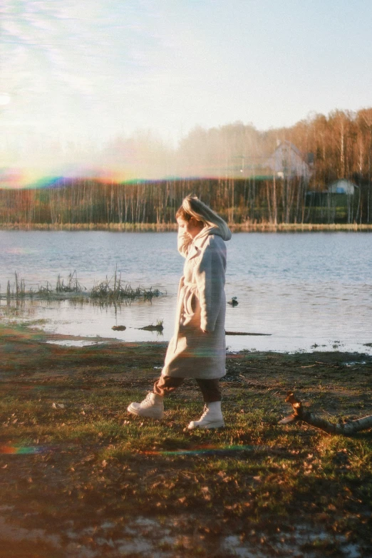 a person standing by a lake in the grass