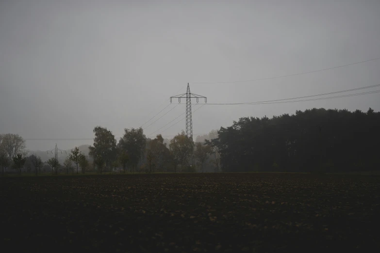 a lone telephone pole is in the distance in a field