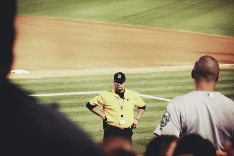 the referee stands beside his umpire on the field