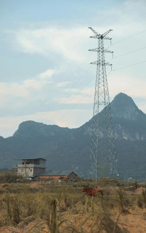 a wire tower with a building in the background