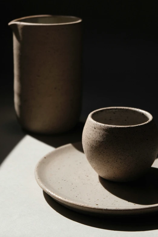 a bowl and two cups on top of a table