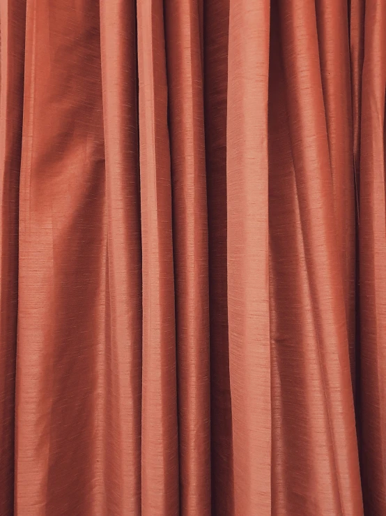 an orange curtain with the bottom half partially closed