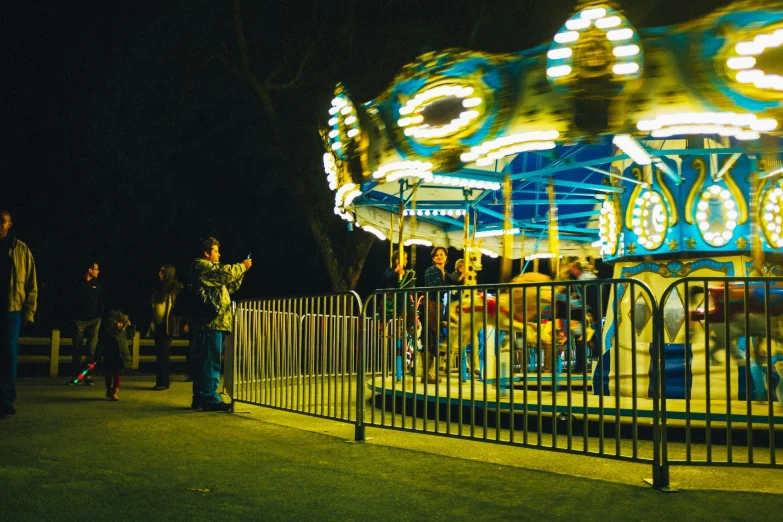 a carousel has people riding it at night