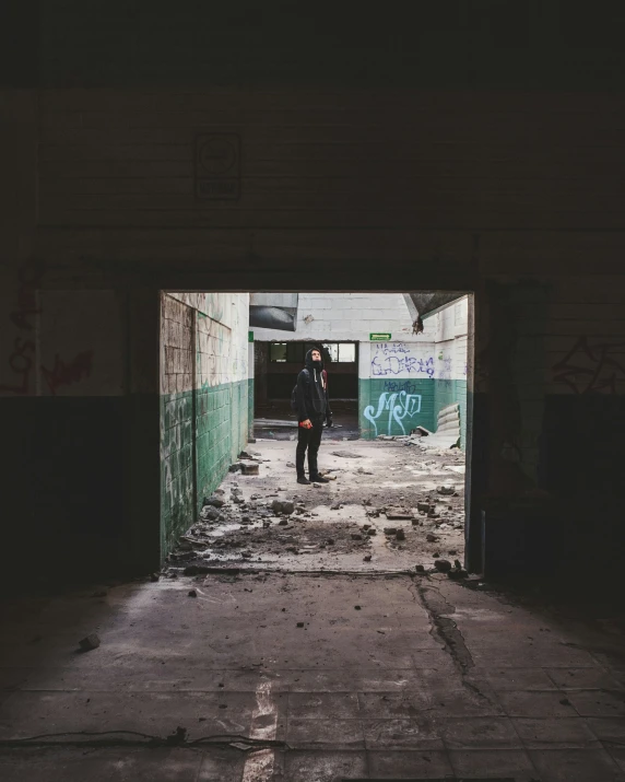 an adult with a child looking out an industrial building doorway