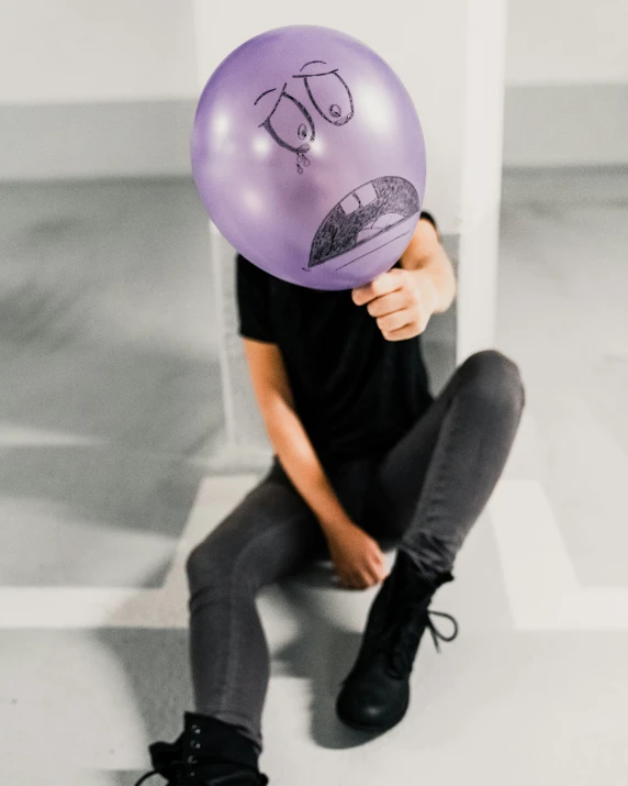 a person wearing a hat holding up a balloon