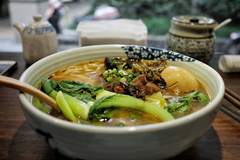 a bowl of asian soup sits on a table