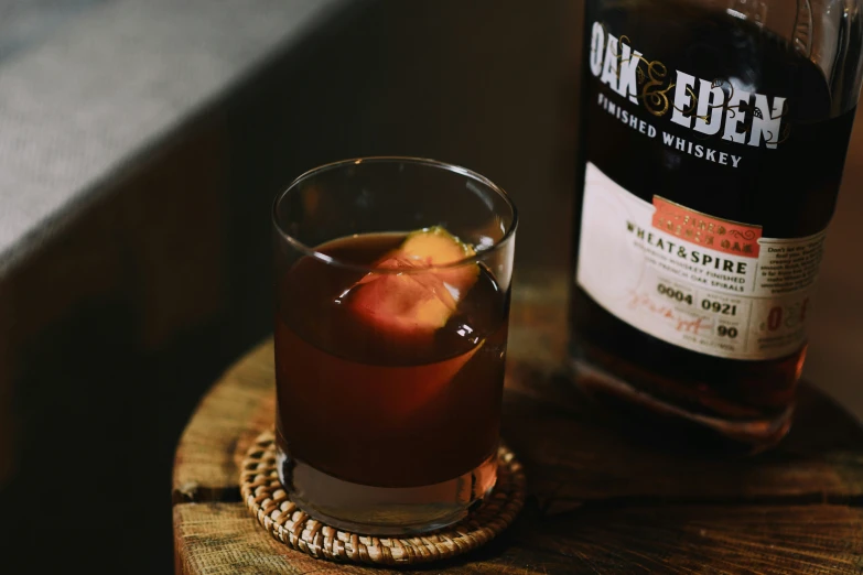 a bottle of booze on a table next to a glass of liquor