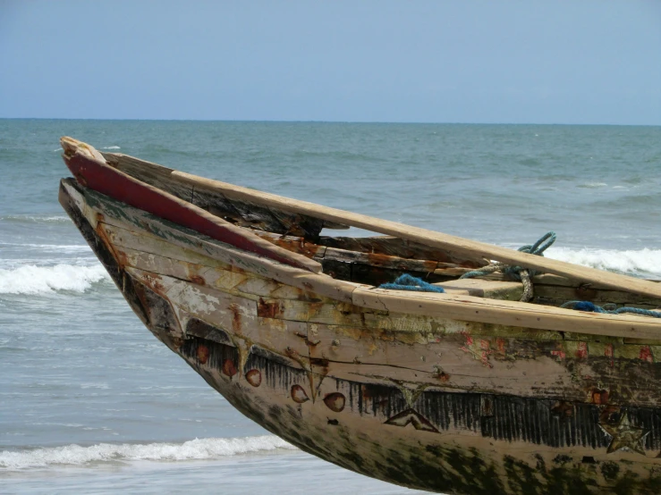 an old boat at the edge of the ocean