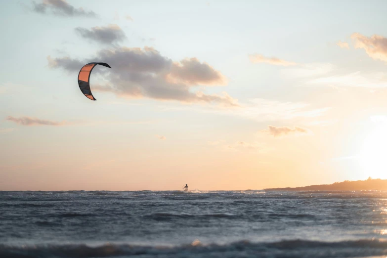 a person is para - sailing on the ocean during sunset