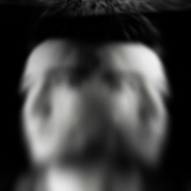 blurry image of a person's face with eyes closed