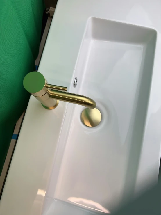 a sink sitting next to a green towel rack