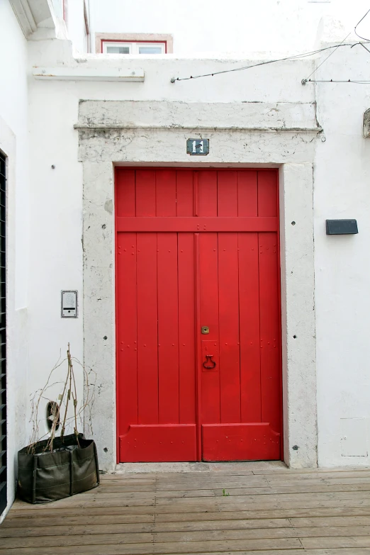 red and grey doors of a house and two large bags in front of them