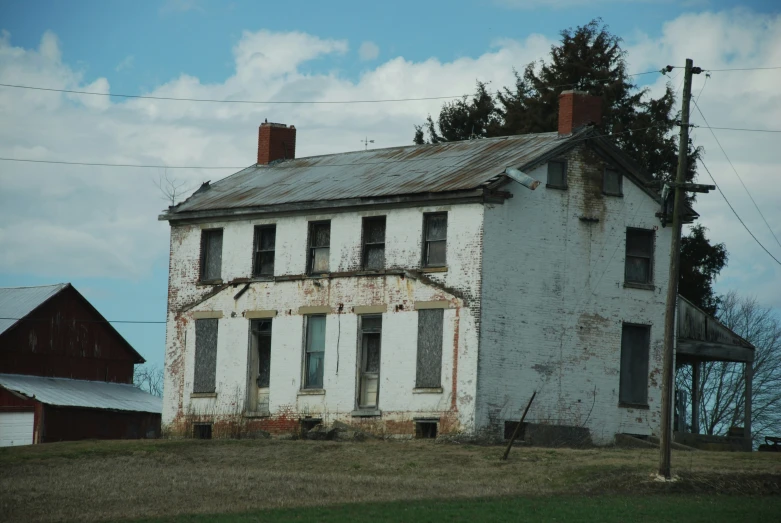 an old rundown house stands on the side of the road